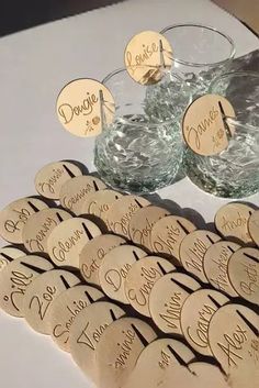 a table topped with lots of glass vases filled with water and small wooden tags