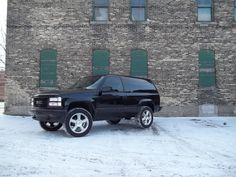 a black suv parked in front of a brick building