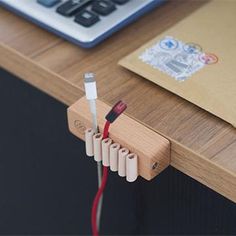 an electronic device is plugged into the charging station on top of a wooden desk