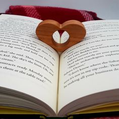 an open book with a wooden heart on it