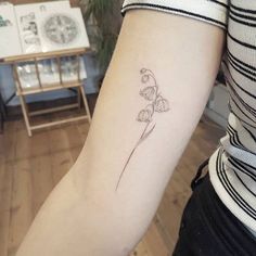 a small flower tattoo on the arm