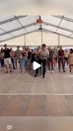 a group of people are dancing in a tent