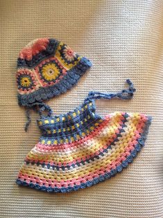 two crocheted hats on top of a bed next to an object that appears to be knitted