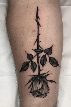 a black and white photo of a flower on the leg, with leaves growing out of it