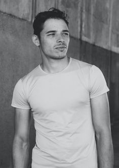 black and white photograph of a man in a t - shirt looking at the camera