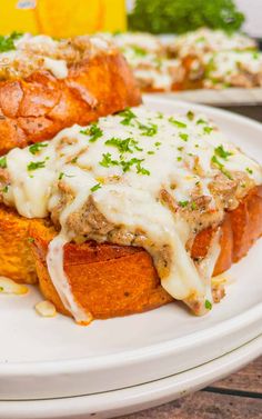 two sandwiches with meat and cheese on a white plate