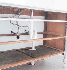 an unfinished kitchen shelf with pipes and piping