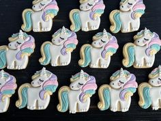 decorated cookies in the shape of unicorns on a table