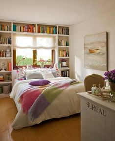 a bedroom with bookshelves and a bed in it