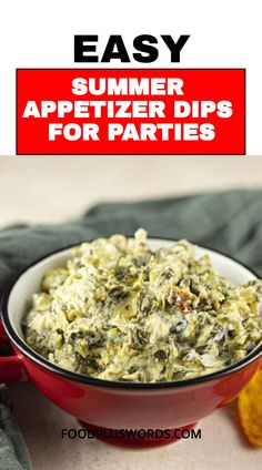 a red bowl filled with spinach dips on top of a table