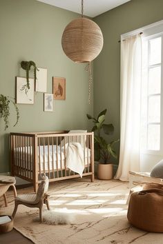 a baby's room with a crib, rocking chair, and large potted plant