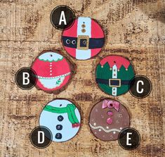 four decorated cookies sitting on top of a wooden table with the letters abc and c