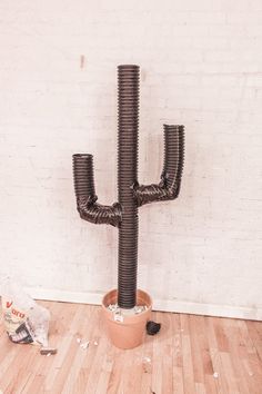 a large metal cactus sitting on top of a wooden floor