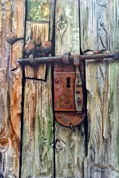 an old padlock is attached to a wooden door with rusted metal knobs