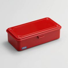 a red lunch box sitting on top of a white table