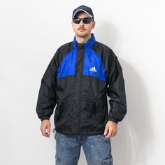 "Vintage Adidas windbreaker in blue-black with white logo on the chest - 2 outer pockets - with a front zip - lined - hood hidden in the collar - material: 100% polyester SIZE size from label: D7, US L, GB 42/44, F 186 best fits men: L MEASUREMENTS chest: 52 inches (132 cm) length: 28 inches (71 cm) sleeve length from armpit: 21,5 inches (55 cm) The model is 6'1\" (186 cm), measures 41-35-39 (104-88-100 cm) and typically wears clothing in size L CONDITION - 8/10 - Good vintage condition. The zip Urban Blue Windbreaker With Double Hood, Black Track Jacket With Fleece Lining For Streetwear, Urban Blue Windbreaker For Outdoor, Vintage Black Windbreaker For Outdoor Activities, Sporty Black Windbreaker With Fleece Lining, Black Sporty Windbreaker With Fleece Lining, Weatherproof Blue Outerwear For Streetwear, Blue Sporty Windbreaker With Fleece Lining, Blue Windproof Outerwear For Streetwear