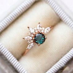 an engagement ring with blue and white stones in a box on top of a table