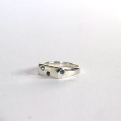 This gorgeous custom, rectangle shaped signet ring is set with the icy winter toned stones. A 2mm blue topaz, 2mm Aquamarine and a 2mm smokey quartz. It is hand cast in sterling silver, perfect to last forever. This is listing is for a size K, it can be custom made to your size but please get in touch to confirm the size. Modern Rectangular Blue Topaz Ring, Silver Rectangular Topaz Ring, Rectangular Silver Blue Topaz Ring, Rectangular Silver Topaz Ring, Modern Blue Topaz Rectangular Rings, Modern Rectangular Birthstone Ring, Signet Rings, Hand Cast, Smokey Quartz