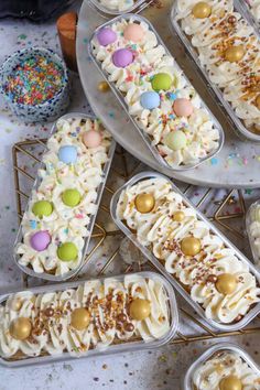 there are many desserts in plastic containers on the table with confetti and sprinkles