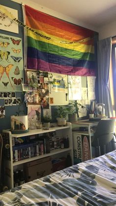 a bed room with a neatly made bed and a rainbow flag hanging on the wall