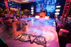 the stage is set up for an event with neon lights and graffiti on the floor