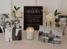 a table topped with pictures and flowers next to a candle