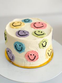 a white cake with smiley faces on it