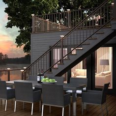 an outdoor dining table and chairs on a deck with stairs leading up to the second floor