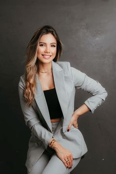 a woman in grey suit posing for the camera