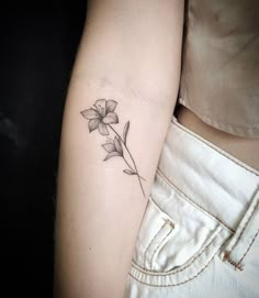 a woman's arm with a flower tattoo on the left side of her arm