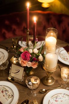 the table is set with candles and plates