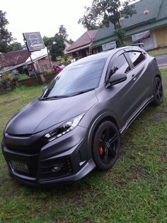 a grey car parked on top of a lush green field