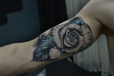 a man with a rose tattoo on his arm