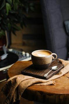 a cup of coffee sitting on top of a wooden table