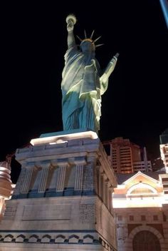 the statue of liberty is lit up at night