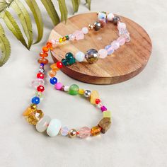 🎉 Step into a world of color and fun with our vibrant 17 inch necklace, a playful and eclectic mix of various gemstones, glass, wood, plastic, and ceramic beads. This handknotted necklace is perfect for those who love bold, unique, and artisanal jewelry. 🔹 Diverse Confetti Bead Mix: Our necklace showcases an exciting array of beads, each chosen for its unique shape, size, and material. Ranging from 4-12mm, the beads come together to create a lively confetti effect. The blend of bright and colorful beads results in a truly fun and eye-catching piece. 🔹 Vibrant Handknotted Design: Each bead is meticulously handknotted on a neon orange nylon cord, providing a strong and vivid backdrop that accentuates the necklace's playful charm. This knotting technique not only adds to the necklace's dur Adjustable Rainbow Beaded Necklaces With Wooden Beads, Adjustable Rainbow Beaded Necklace With Wooden Beads, Adjustable Multicolor Whimsical Beaded Necklaces, Whimsical Adjustable Multicolor Beaded Necklaces, Adjustable Multicolor Whimsical Beaded Necklace, Handknotted Necklace, Mixed Beads Necklace, Crystal Confetti, Plastic Beads