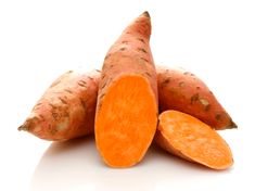 three sweet potatoes with their tops cut off and sitting next to each other on a white surface