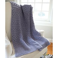 a blue blanket sitting on top of a white chair