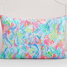 a colorful pillow sitting on top of a white bed