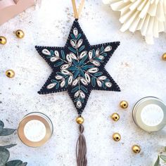 an ornament hanging on a table next to candles and other holiday decor items