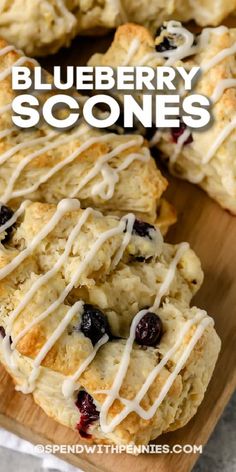 blueberry scones with icing drizzled over them on a cutting board