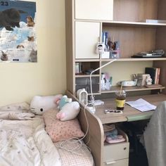 a bedroom with a bed, desk and bookshelf filled with stuff animals on it