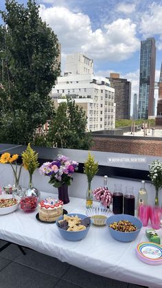 a table topped with lots of food and drinks on top of a white table cloth