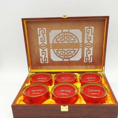 a wooden box filled with red teas on top of a table