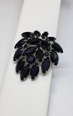 Elegant and chic help describe this midnight black onyx glass brooch. Featuring black marquis stones and black chatons. It is 2 in. long and 1 1/2 in. wide. It is in excellent vintage condition. This is most likely attributed to WEISS (not signed) and I have listed separately the matching elegant necklace which is signed WEISS. ENJOY Albert Weiss worked for the CORO company in the 1930's and learned the trade then in 1942 he opened his own company. The company excelled quickly. They focused on t Black Brooch For Formal Occasions, Black Brooch Jewelry For Wedding, Black Brooch Pins For Party, Black Party Brooch Pins, Vintage Black Party Pins, Black Brooch Pins For Evening, Black Brooch Jewelry For Party, Black Party Jewelry Brooch, Dressage Stock Tie