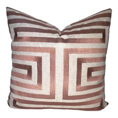 a brown and white striped pillow on a white background with a square design in the middle