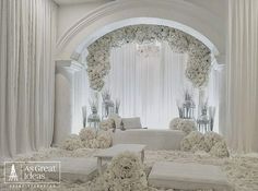 a white wedding ceremony with flowers and couches