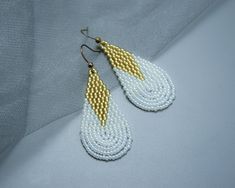 Elevate your bridal look with our exquisite Teardrop Bridal Earrings. These stunning dangle earrings are meticulously handcrafted using high-quality seed beads, creating a mesmerizing beaded pattern that catches the light beautifully. Crafted in elegant white and gold, these earrings exude a timeless and sophisticated charm, making them the perfect accessory for your special day. The delicate teardrop shape adds a touch of grace and elegance, ensuring you feel like a true princess as you walk do Wedding Dangle Earrings, Teardrop Bridal Earrings, Earrings White Gold, Dangle Earrings Wedding, Motifs Perler, Photo Gold, Beading Jewelry, Earrings Bridesmaid, Earrings Beaded