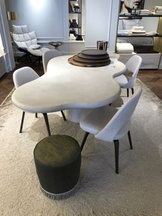 a white table and chairs in a room with rugs on the floor next to it