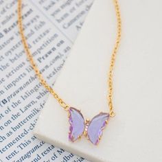 Shine in this playful acrylic butterfly necklace. Features transparent gem tone wings with crystal sparkle body. Measures 16" + 3" extension.Butterfly .5" x .75" Trendy Butterfly Necklaces For Party, Butterfly Charm Necklace For Party, Purple Butterfly Charm Jewelry For Party, Pink Butterfly Necklace For Party, Gem Tones, Butterfly Pendant Necklace, Butterfly Necklace, Butterfly Pendant, Arrow Necklace